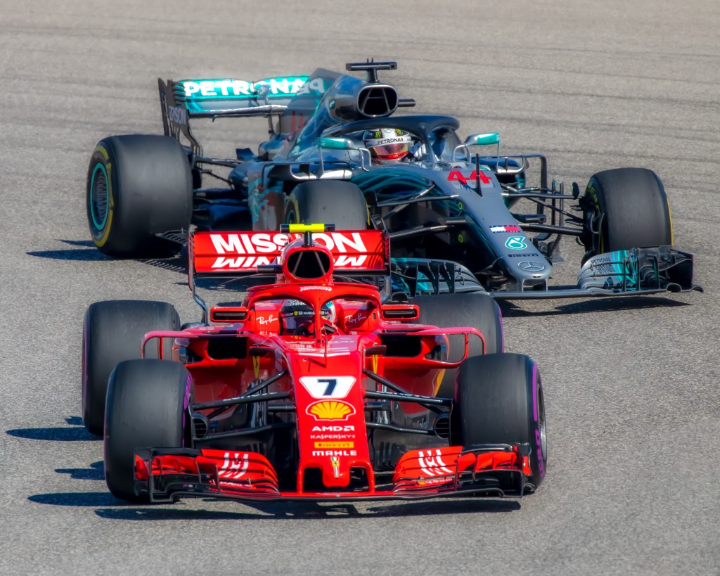 Formuła 1, bolidy ścigające się na torze, srebrny Mercedes jedzie za czerwonym Ferrari